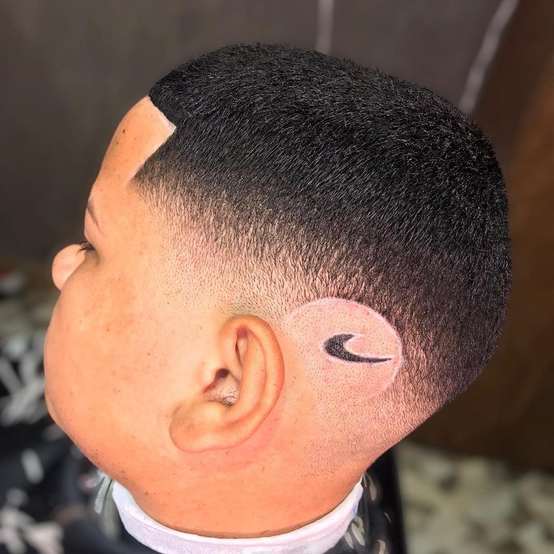 Logo da Nike desenhado na lateral da cabeça, acima da orelha